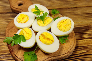 Boiled eggs with parsley on cutting board on a wooden table