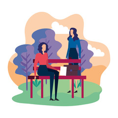 elegant businesswomen seated in the park chair