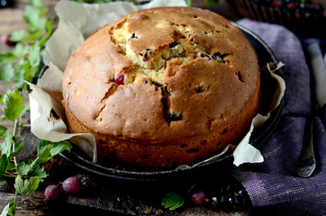 Cake with gooseberries on a dark wooden background