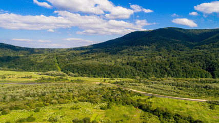 Fototapeta premium aerial shoot of green landscape in the mountains