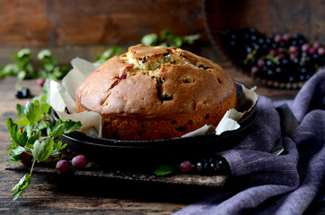 Cake with gooseberries on a dark wooden background