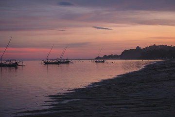 bali beach with fishing boats during sunset