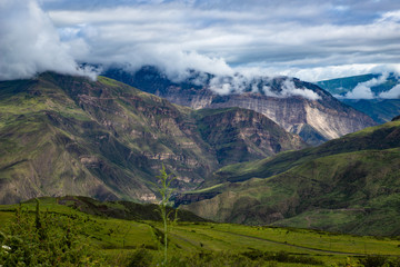 Fototapeta premium Mountain landscape beautiful green mountains with Alpine lush meadows cloudy sky background.