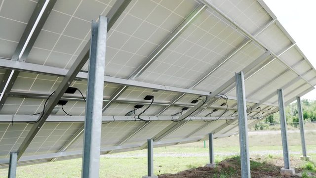 back side view rows array of polycrystalline silicon solar cells or photovoltaics in solar power plant