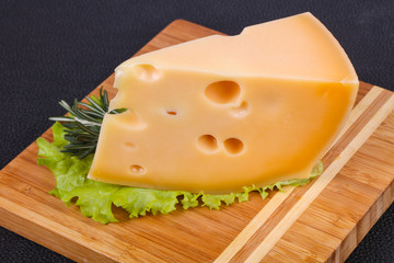 Maasdam cheese  in the board served salad leaves