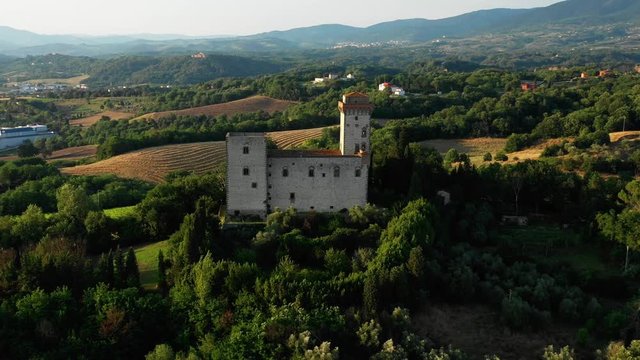 Aerial view of a beautiful old stone european building located on a hill in a picturesque place among the thickets and trees on a sunny summer day. Concept of tourism in ancient European places