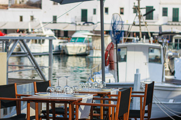 Free table and empty chairs of fish restaurant in the port of Ciutadella town, Menorca, Balearic islands, Spain