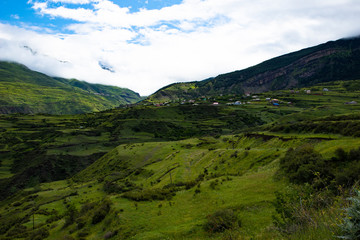 Fototapeta na wymiar Mountain landscape beautiful green mountains with Alpine lush meadows cloudy sky background.