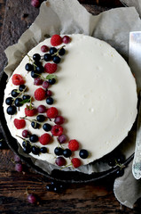 Cheesecake with fresh berries on a dark wooden background