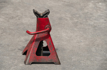 Used red high lift jack stand on the floor.