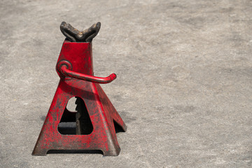 Used red high lift jack stand on the floor.