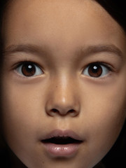 Close up portrait of little and emotional asian girl. Highly detail photoshot of female model with well-kept skin and bright facial expression. Concept of human emotions. Looks shocked, astonished.