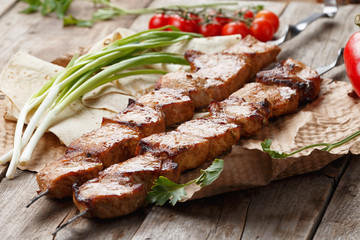 pork skewers on a wooden table, selective focus