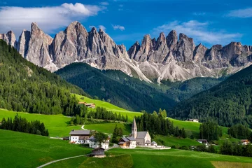 Fotobehang De St Magdalena-kerk met de Odle-bergketen die erboven torent, Funes-vallei, Dolomieten, Italië. © Alberto