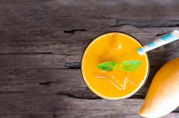 Mango smoothies colorful fruit juice milkshake blend beverage healthy high protein the yummy In glass,drink to lose weight drink isolated wood background from the top view.