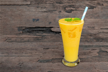 Mango smoothies juice orange fruit juice milkshake blend beverage healthy high protein the taste yummy in glass episode drink morning on wood background.