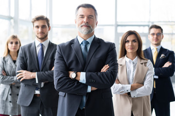 Happy business team with arms crossed at the office.
