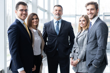 Happy business team with arms crossed at the office.