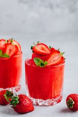 Fresh strawberry rhubarb and watermelon granita with mint on gray stone background
