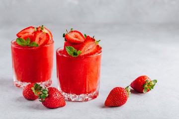 Fresh strawberry rhubarb and watermelon granita with mint on gray stone background