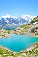 Naklejka na ściany i meble Stunning Alpine landscape with turquoise Lake Blanc, Lac Blanc photographed on a clear summer day. Mount Blanc and other high mountains in background. Beautiful France. Nature scenery