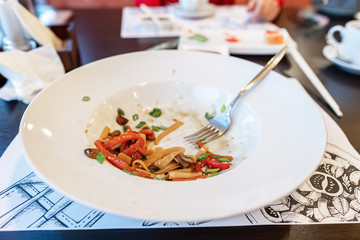 dirty dishes. sauce smeared on a plate. leftovers, pasta, restaurant. didn't finish customers. side view,