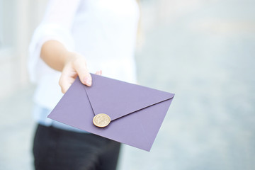 Young girl holds mail invitation cards in her hand. Envelopes with wax seal in hands close-up.