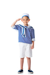 full length view of smiling preschooler child in sailor costume saluting and looking at camera isolated on white