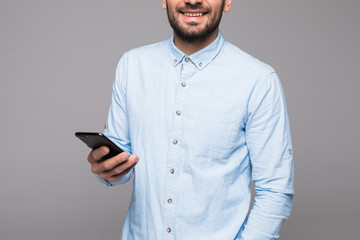 Close up of man using mobile smart phone on a gray background