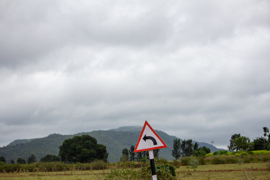 Indian road sign indicating curve ahead, Hasanur, Tamil Nadu, India
