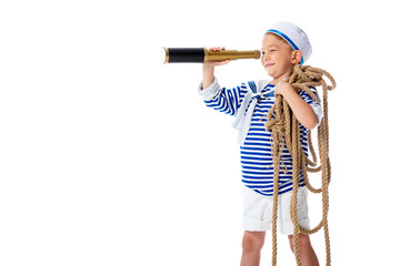 smiling preschooler child in sailor costume looking in spyglass and holding rope isolated on white