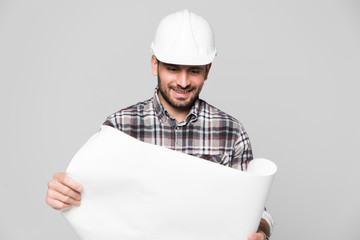 Portrait of male site contractor engineer with hard hat holding blue print paper isolated over white background.