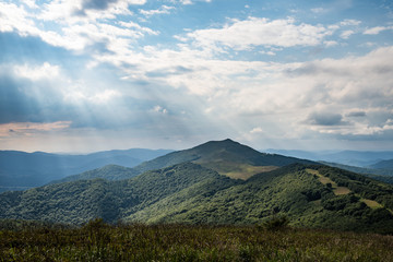 Sun shines through the clouds at at the Smerek peak and Szare Berdo pass, seen from Połonina Wetlińska, from the Osadzki Wierch approach.