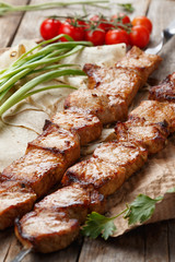 pork skewers on a wooden table, selective focus