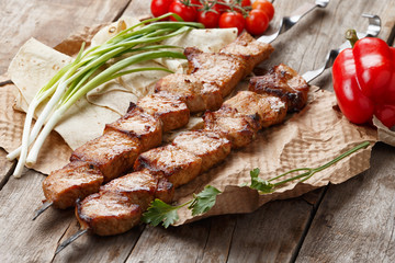 pork skewers on a wooden table, selective focus