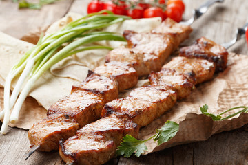 pork skewers on a wooden table, selective focus
