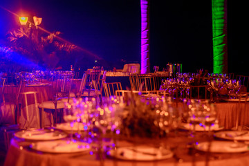 Obraz premium Served tables at the banquet in purple tones. Night photo.