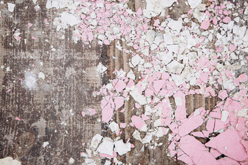 the texture of old wooden boards covered with brittle dry paint of white and pink color that cracked