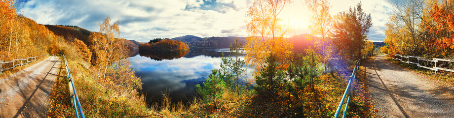 Naklejka na ściany i meble Panoramic autumn landscape with spectacular sunset over river