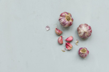 Garlic bulbs and cloves on gray wooden background. Harvest concept. Top view. Flat lay.
