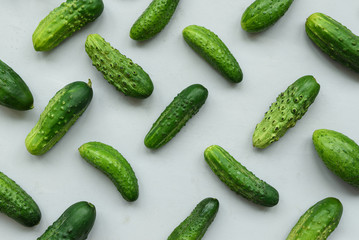 Green cucumbers pattern on gray wooden background. Harvest concept. Top view. Flat lay.