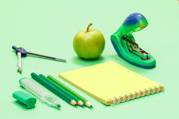 School supplies. Compass, color pencils, notebook, apple and stapler.