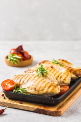 Stuffed grilled chicken breasts in cast iron skillet. Selective focus, copy space.