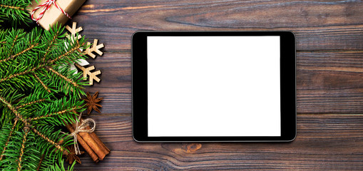 Digital tablet mock up with rustic Christmas wood background decorations for app presentation. top view banner with copy space
