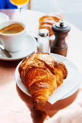 Breakfast with coffee and croissants on table