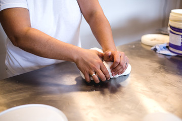 A woman decorates and makes cakes in a pastry shop