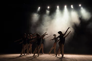 Fototapete Tanzschule Ballet class on the stage of the theater with light and smoke. Children are engaged in classical exercise on stage.