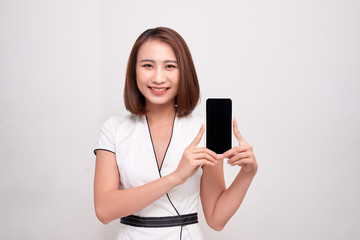 Asian beautiful business woman holding and showing white mobile phone with blank black screen