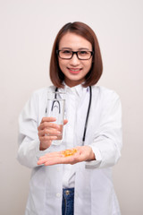 Doctor woman holding water and medicine on white background