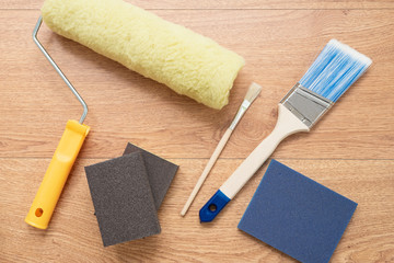 Painting brushes and rollers on wooden background. Building tools for painting surfaces